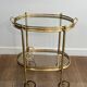 Small oval rolling table in brass with double removable trays from Maison Bagués.