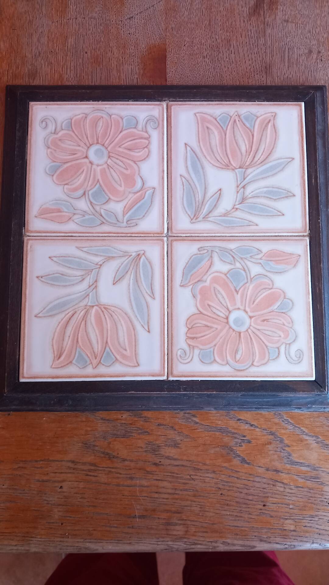 Ceramic tile trivet with floral patterns in pastel tones.