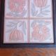 Ceramic tile trivet with floral patterns in pastel tones.
