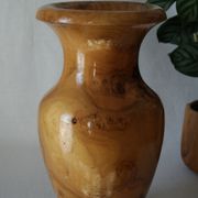 Artisanal turned olive wood vase with varnish.