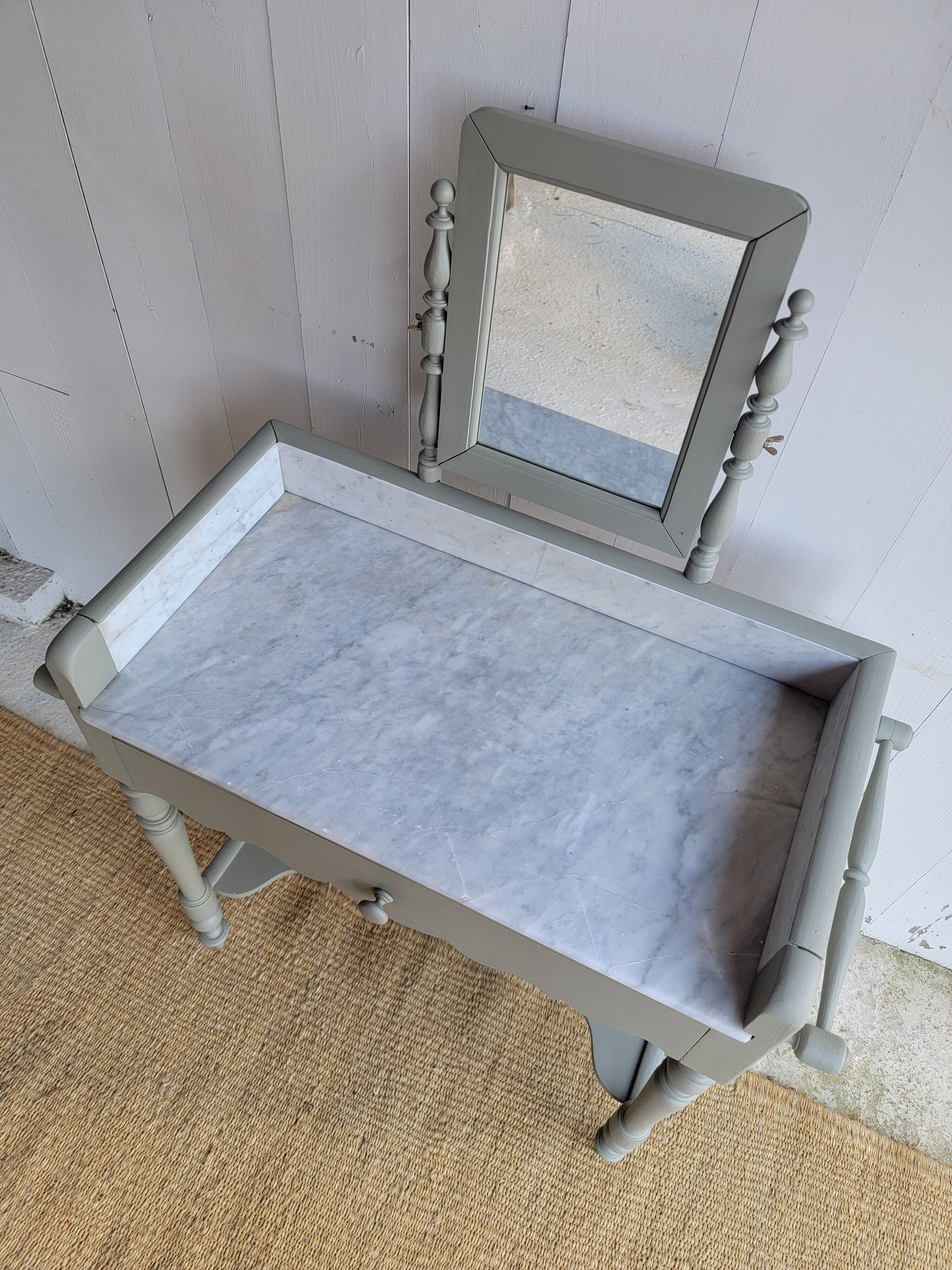 Antique wooden dressing table with marble top and mirror.