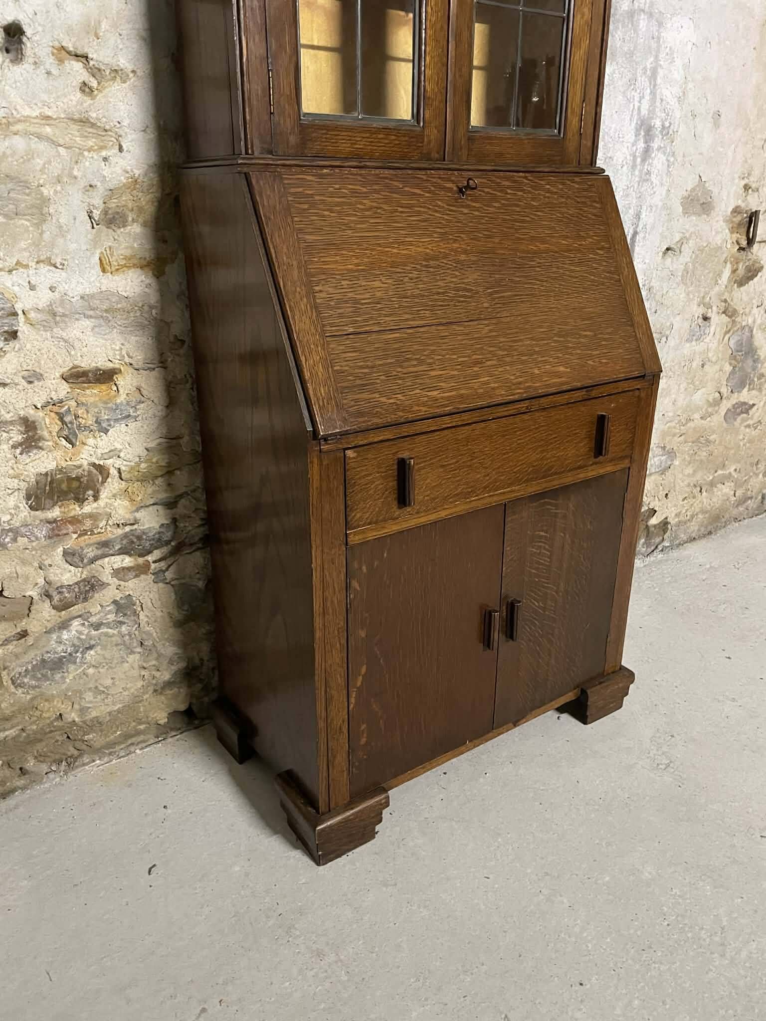 Oak display secretary cabinet with drop-down front, two sections.