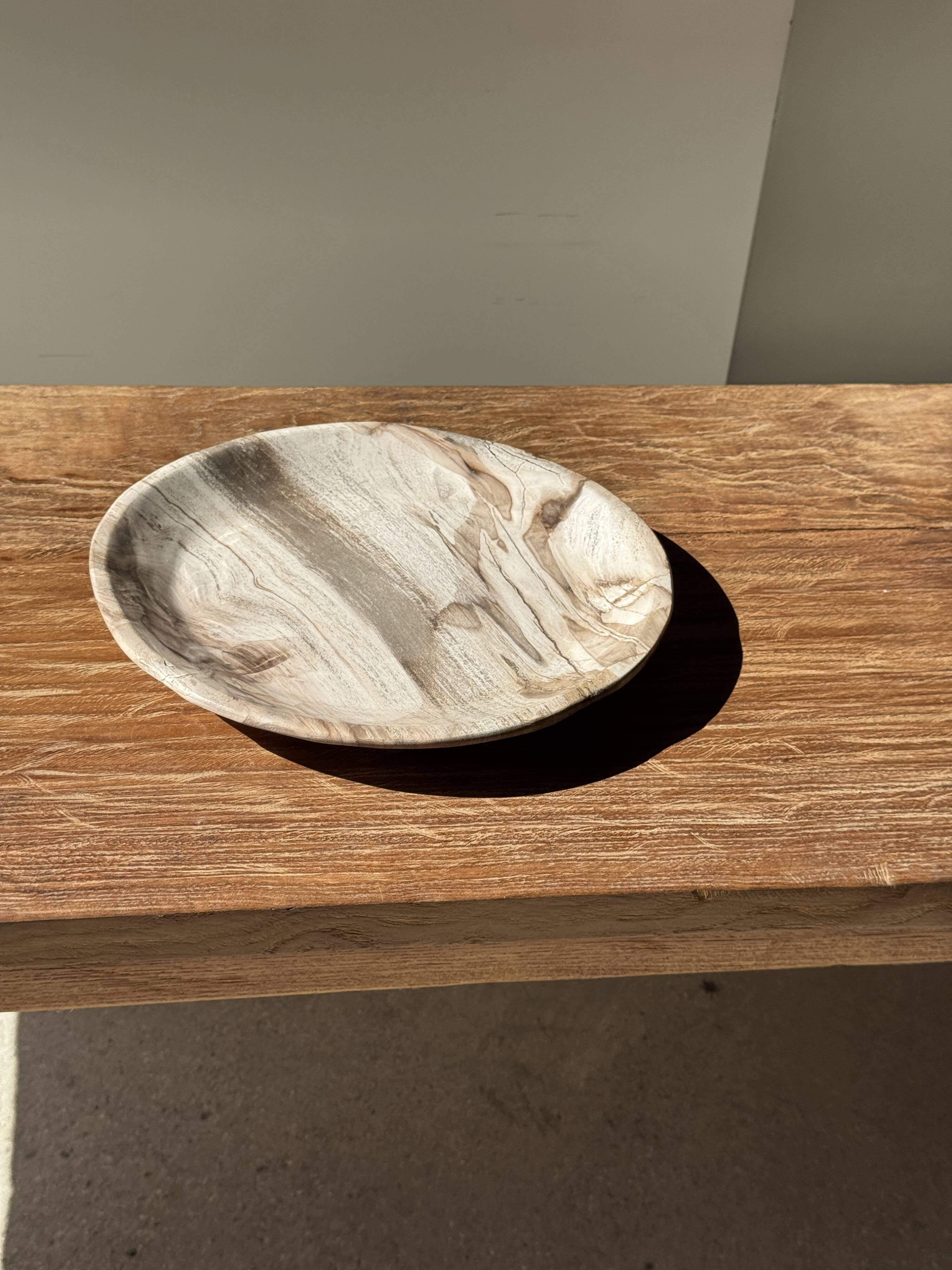 Tray, circular dish or plate made of white striped grey petrified wood.