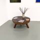 Brutalist coffee table in solid teak, monolithic slab, tripod base.