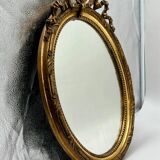 Antique oval gilded mirror with wooden frame and stucco detail