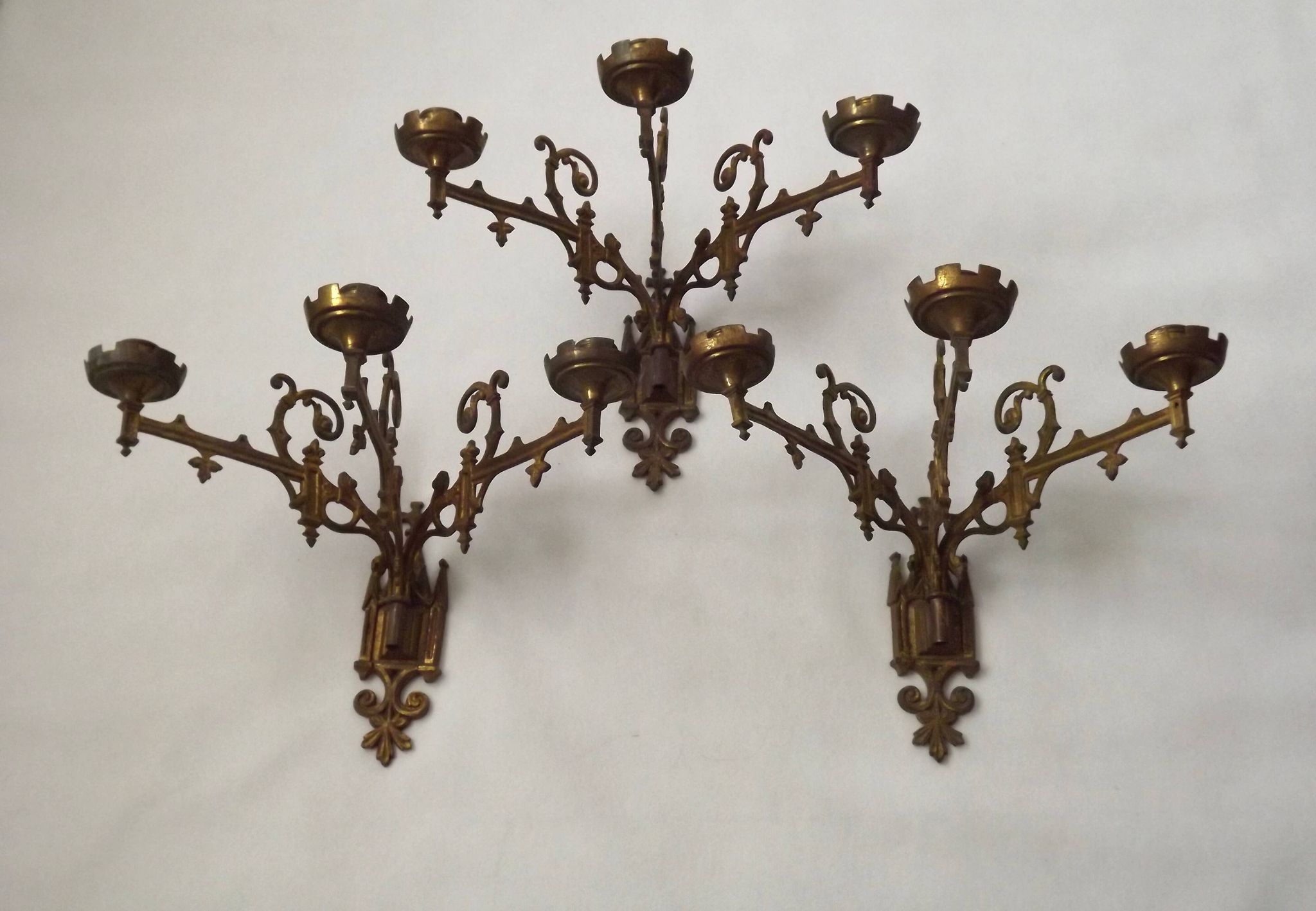 Ensemble élégant de trois appliques murales en bronze doré de style gothique français.