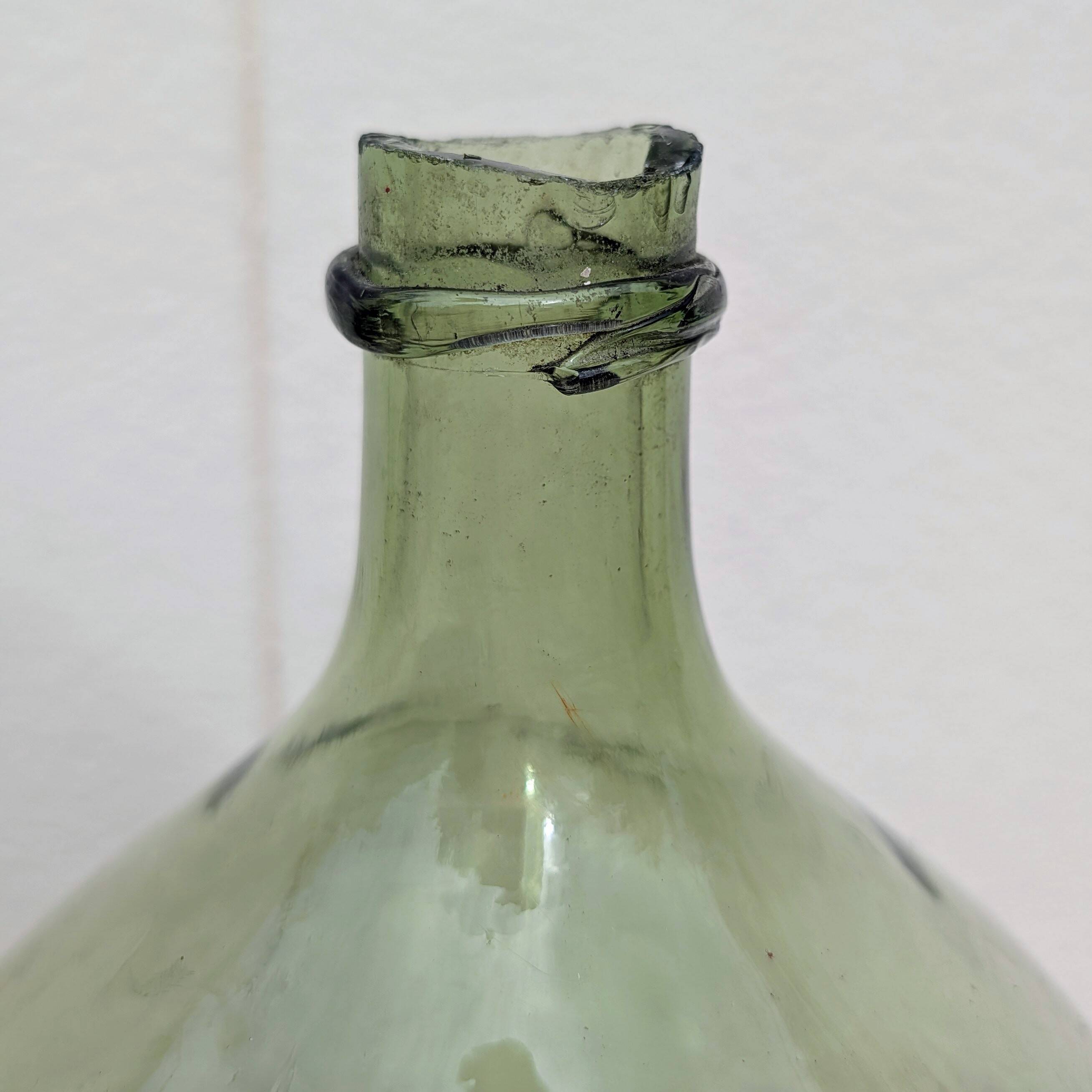 Give me a green glass jug made of blown glass.