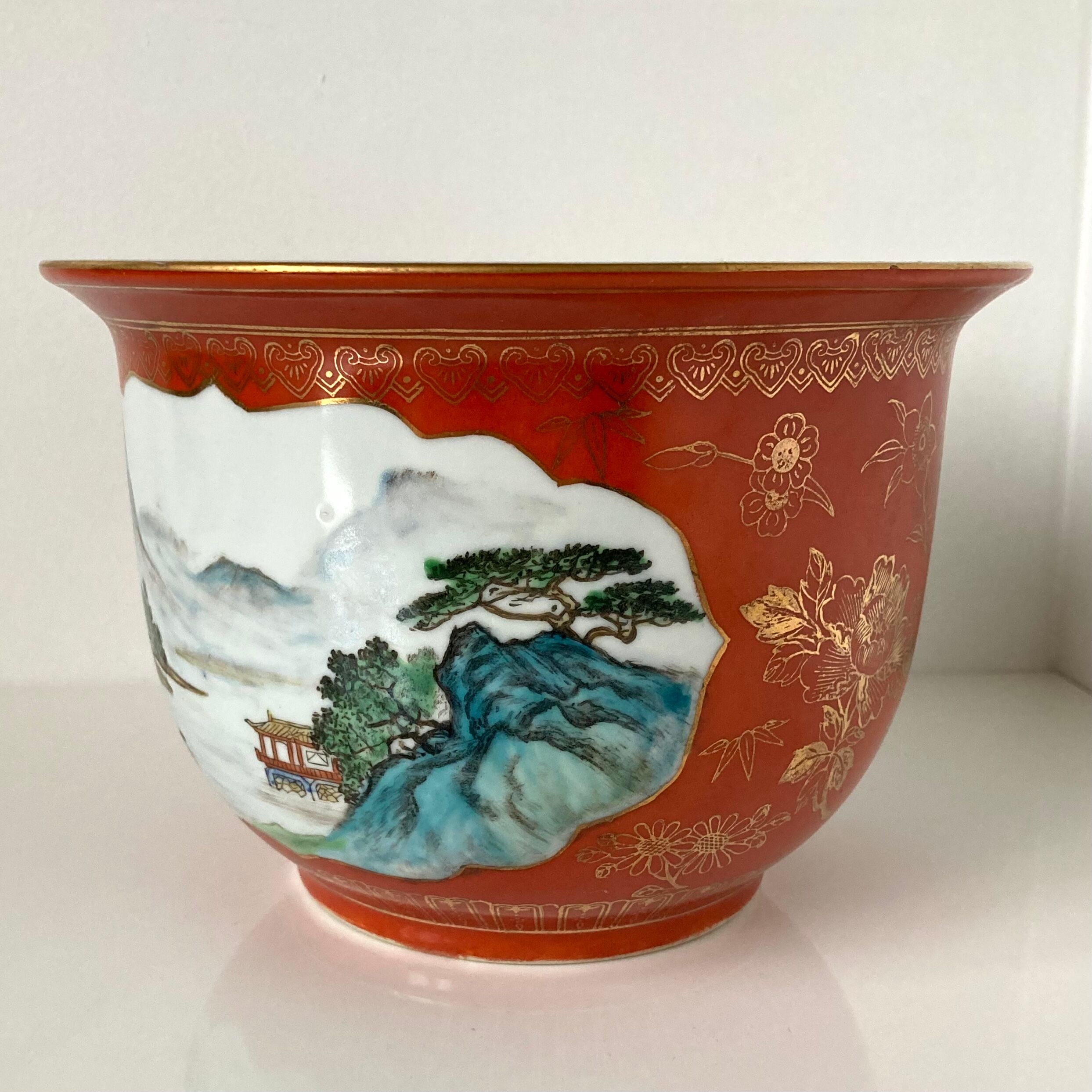 Chinese planter or Chinese porcelain pot cover decorated with landscapes on a coral and golden background