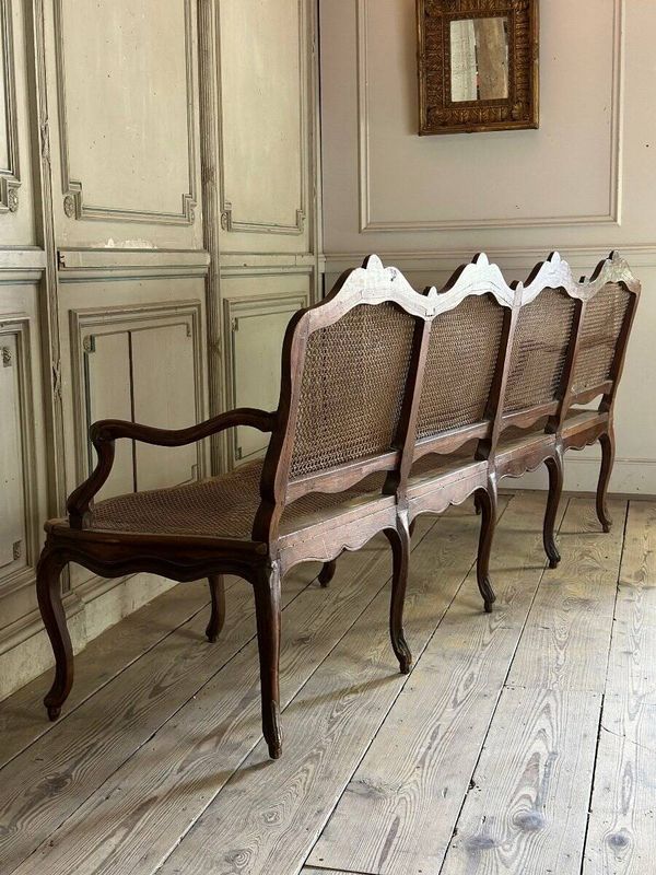 Grande banquette Louis XV en bois naturel mouluré et sculpté, France XVIIIème siècle