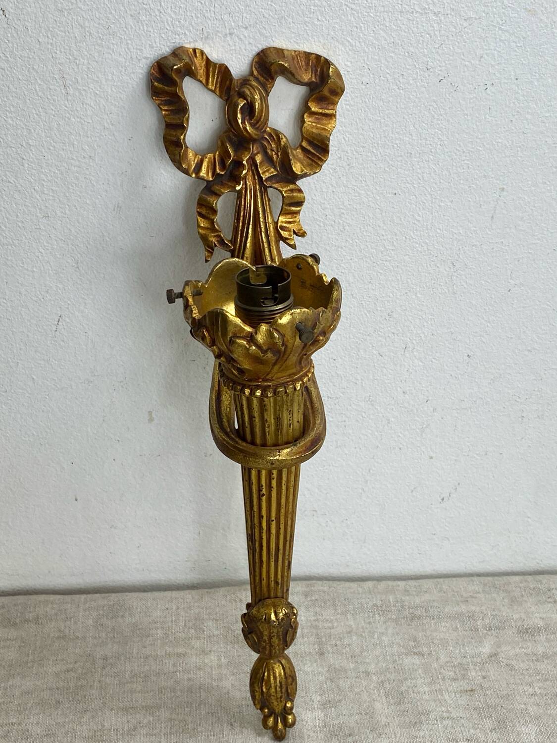 Bronze wall light, decorated with a bow and ribbon.