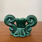 Green ceramic candlestick with curled handles.