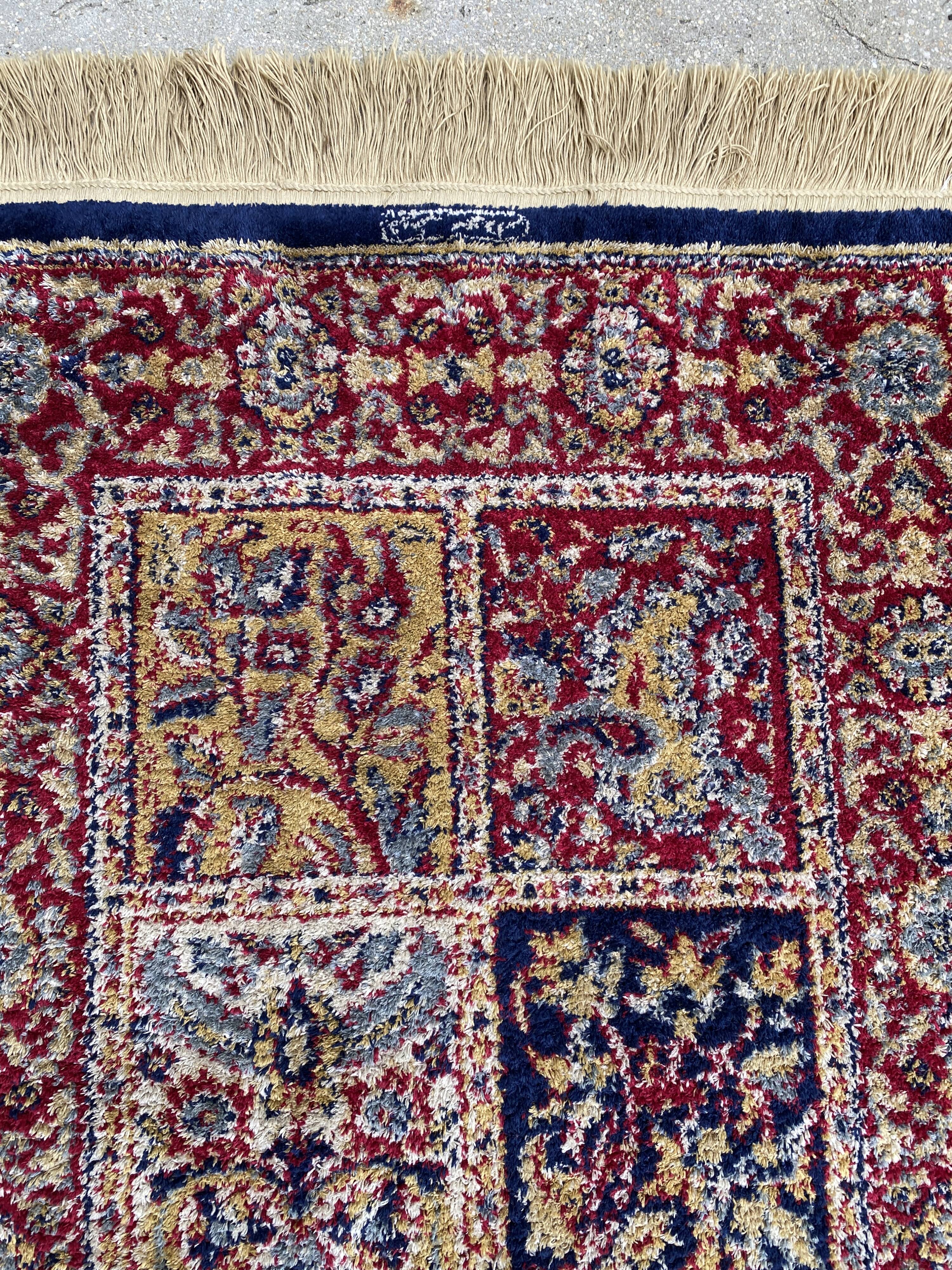 Vintage mechanical Turkish rug with box decoration on a red and navy blue background 139 x 68 cm