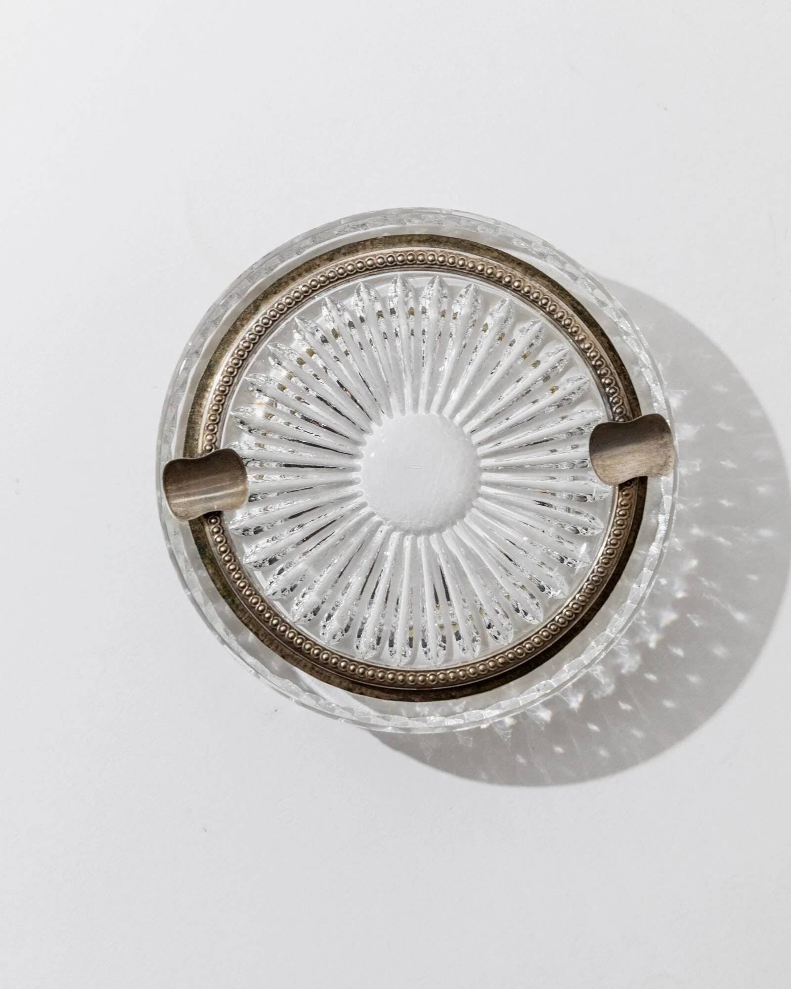 Vintage crystal glass ashtray from the 1920s, silver-edged with a textured pattern, Art Deco table decoration.