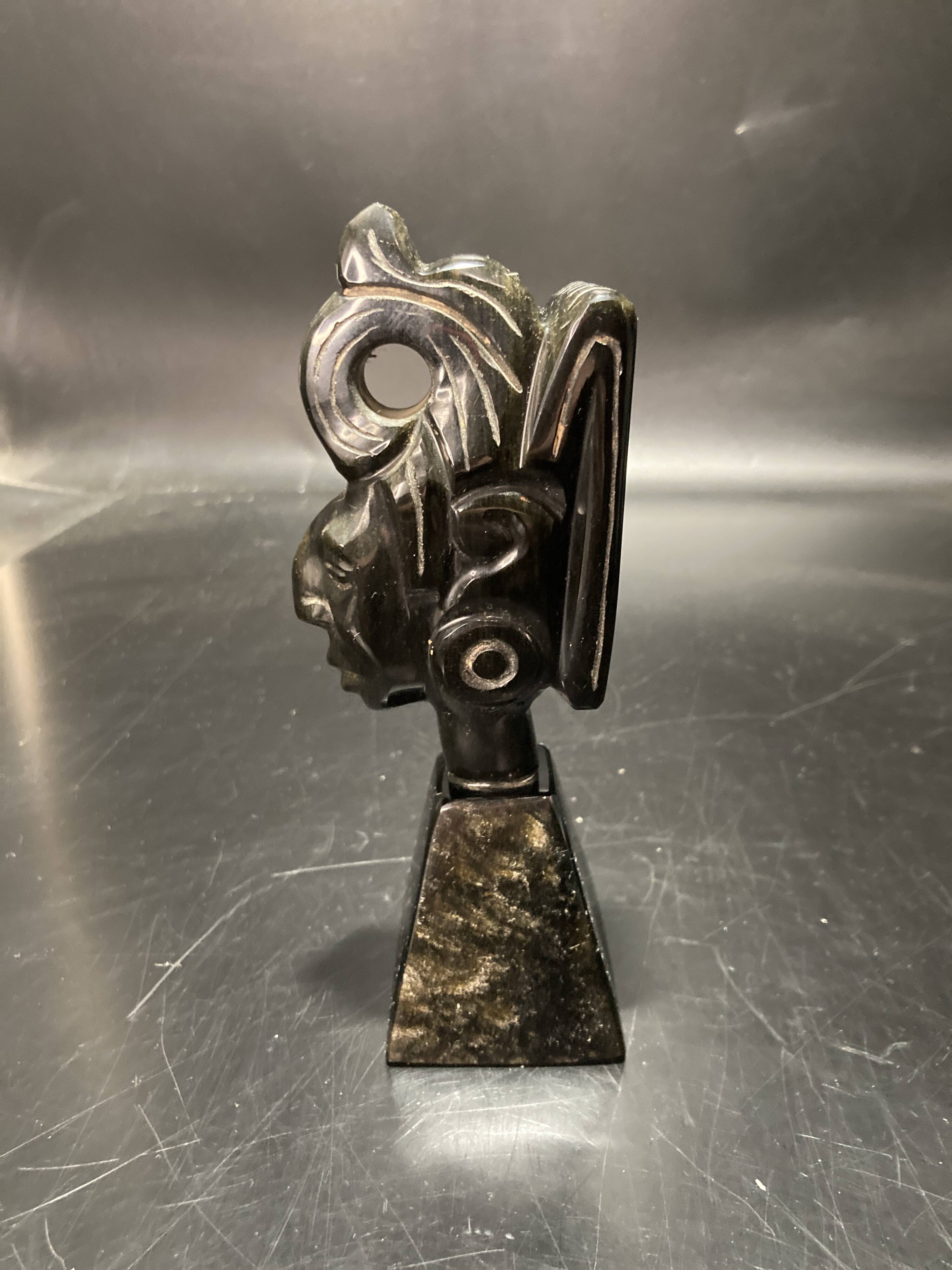 Ceramic sculpture representing a woman's face placed on a black base