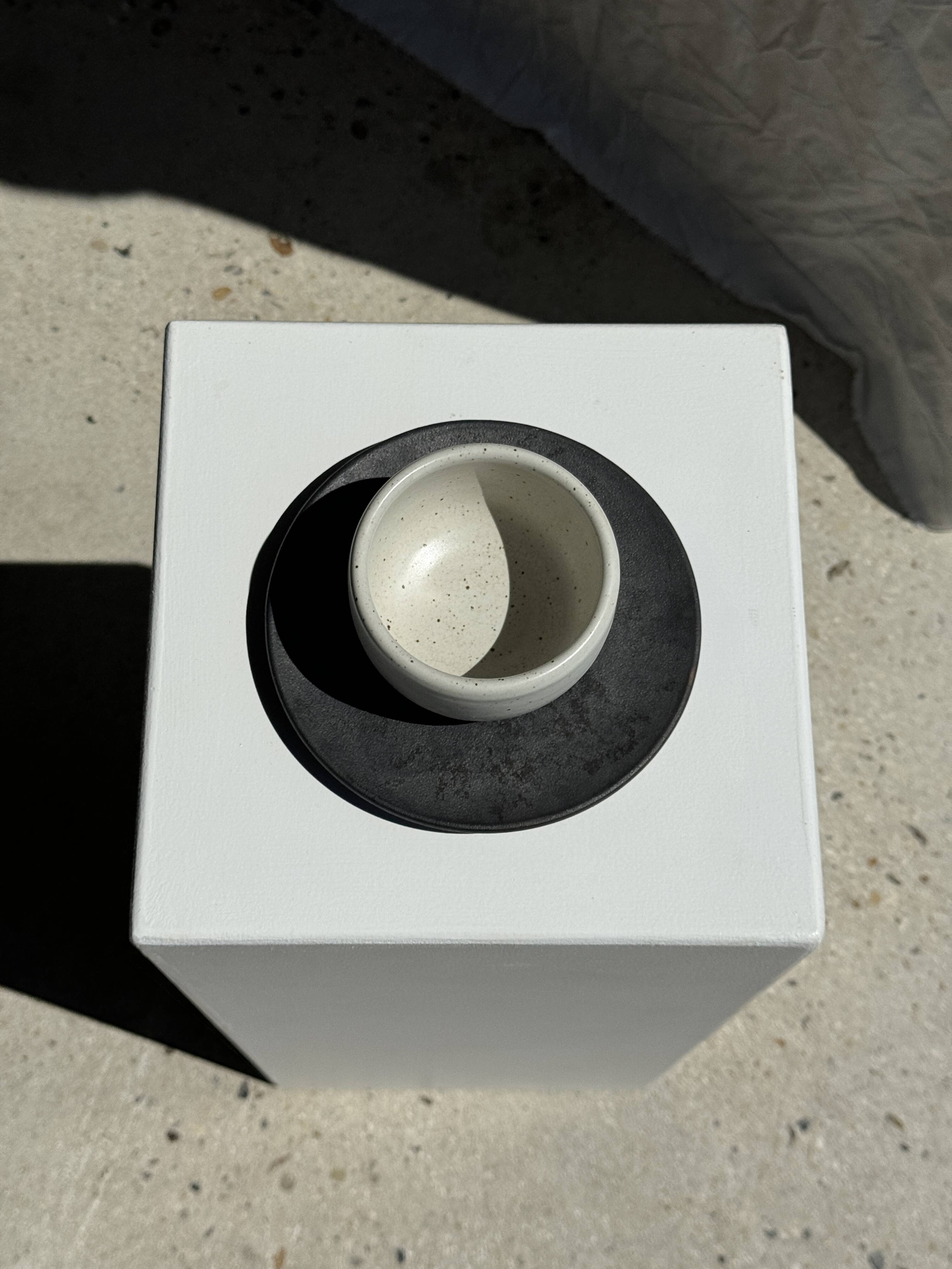 White Indonesian ceramic cup and gray saucer