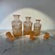 Set of 3 vintage pink glass bottles with corks.