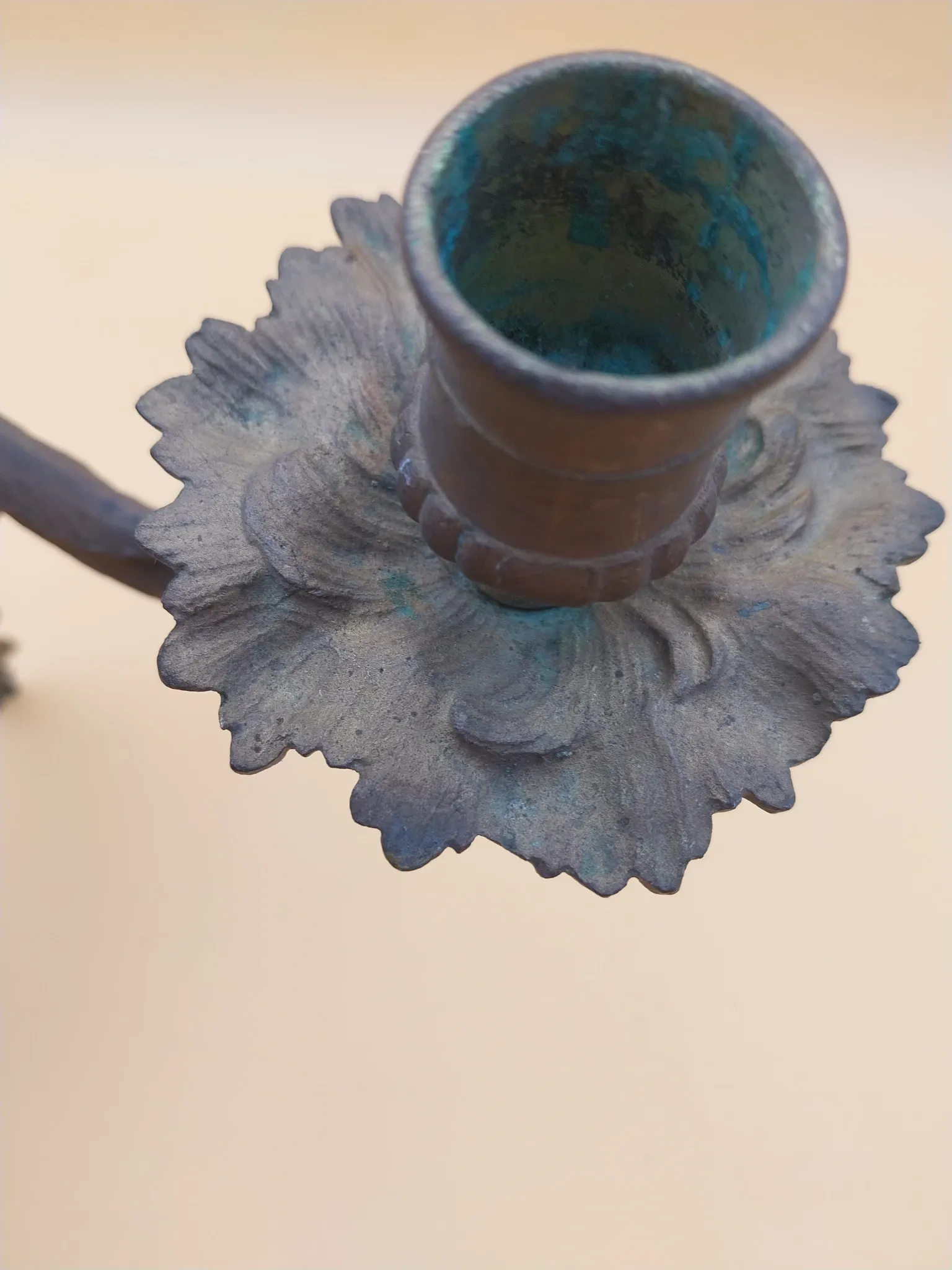 Pair of wall sconces in bronze candle holders with leaf medallion decoration.
