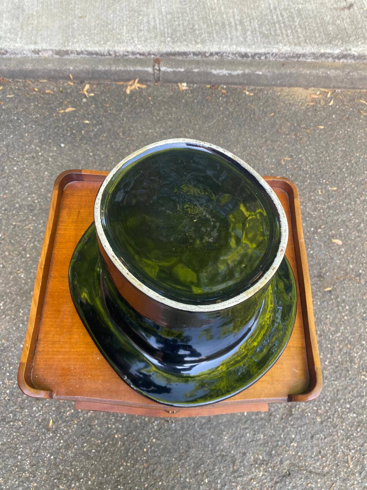 A black top hat-shaped vale turned upside down from the 1960s.