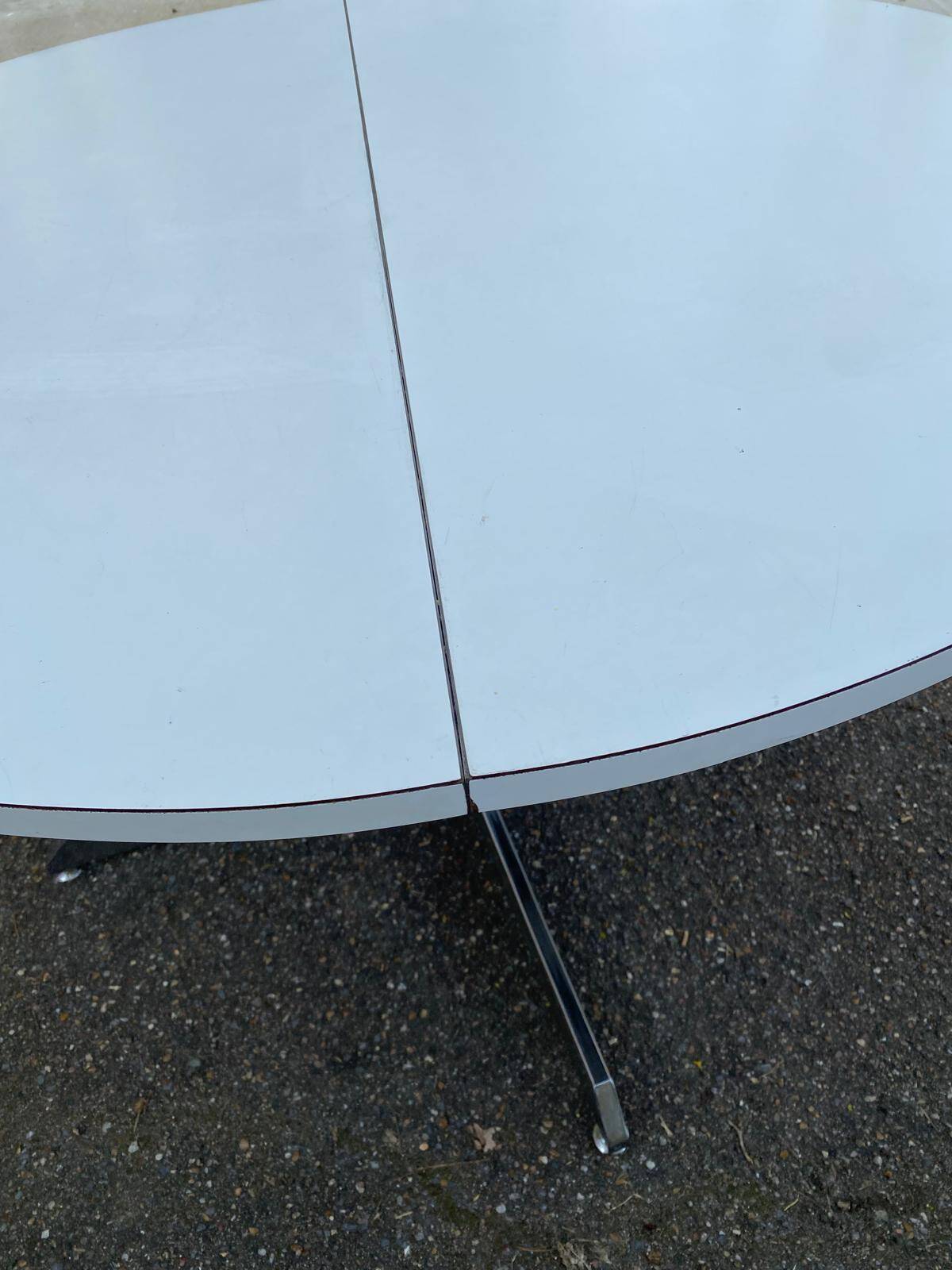 White dining table with a central pedestal, extendable, from the 1970s.