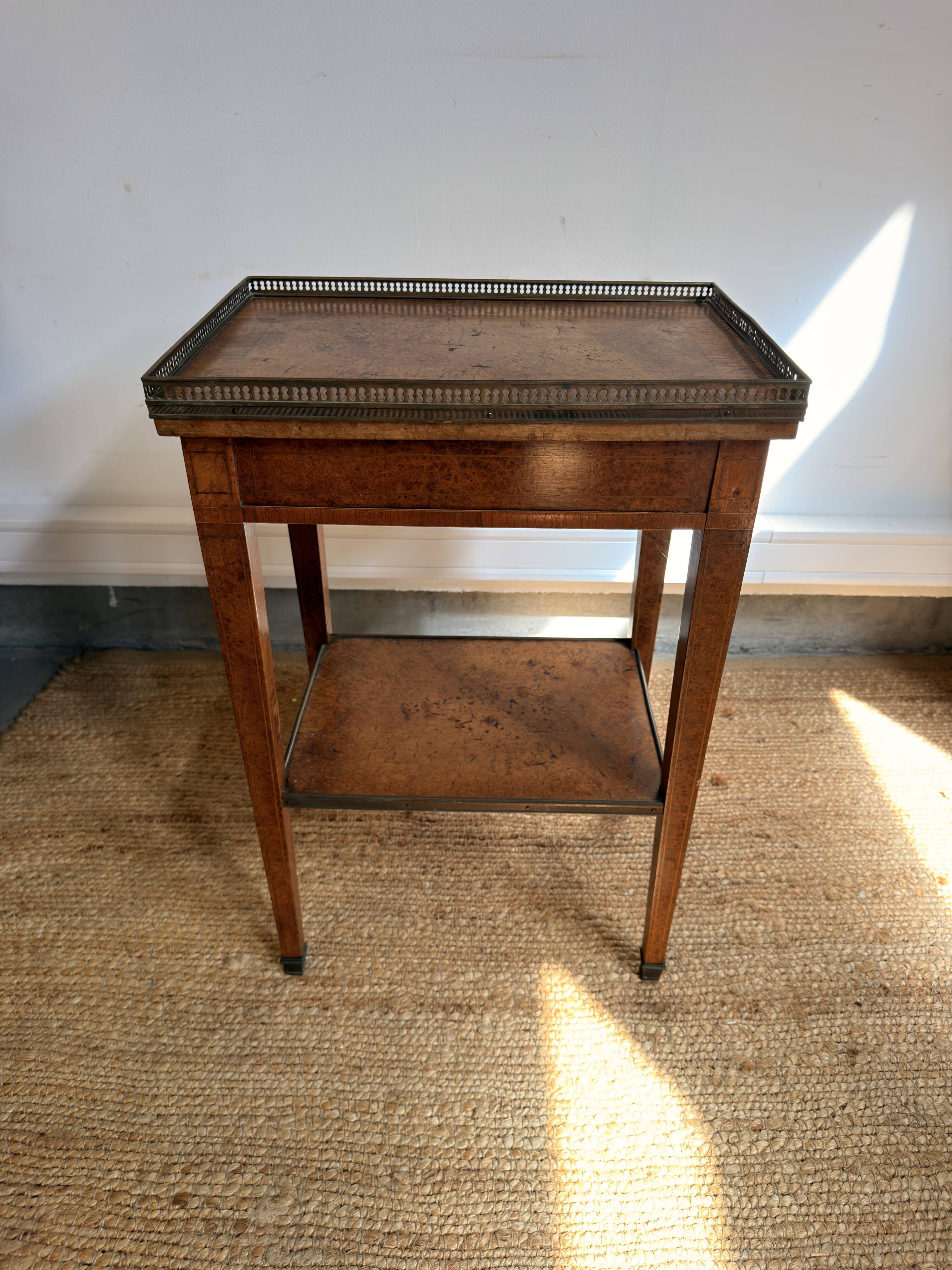 Occasional table in walnut burl and brass gallery.