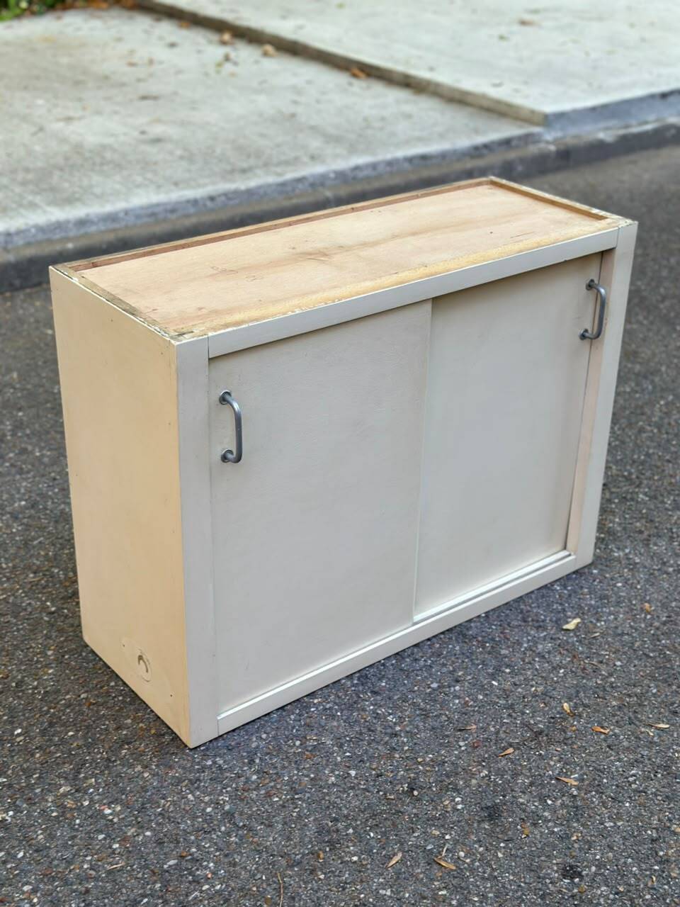 Vintage wall-mounted kitchen cabinet with sliding doors in 1960s retro style.