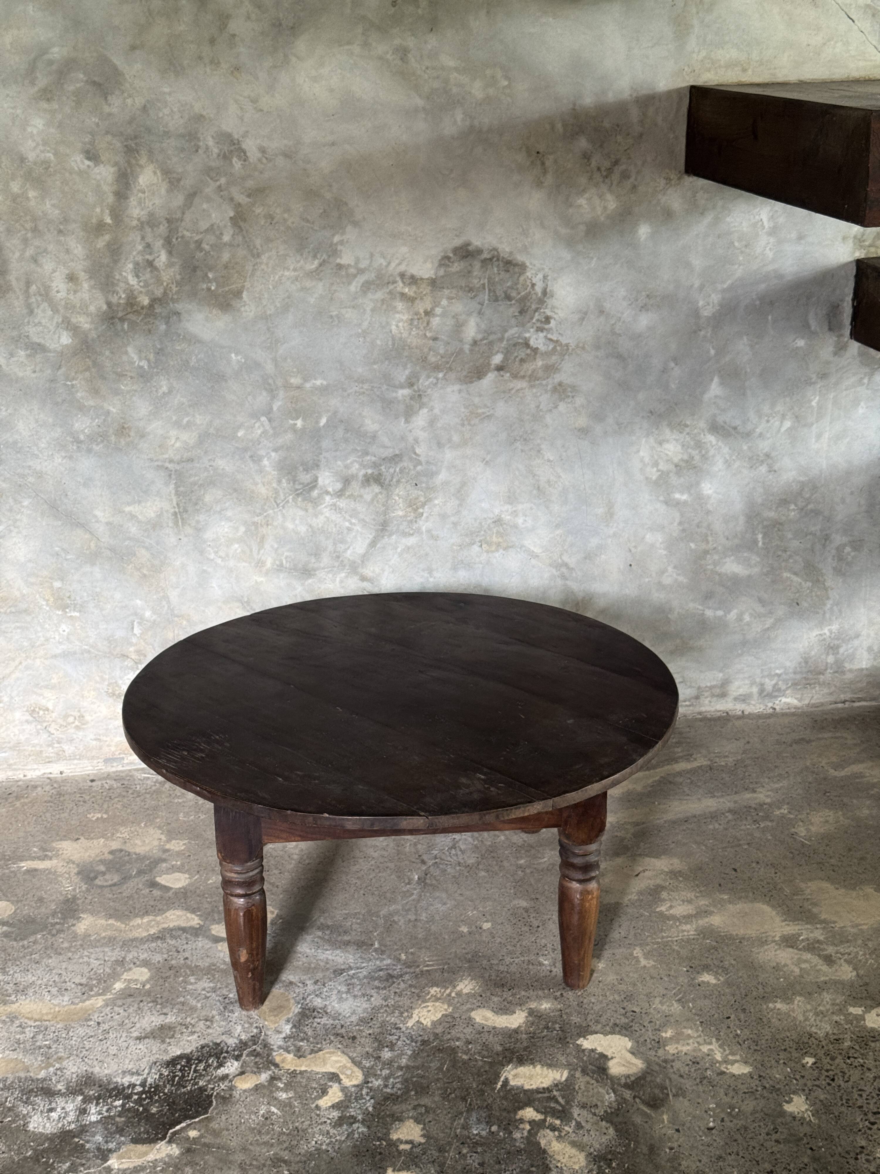 Coffee table, round antique Indonesian teak table with straight legs.