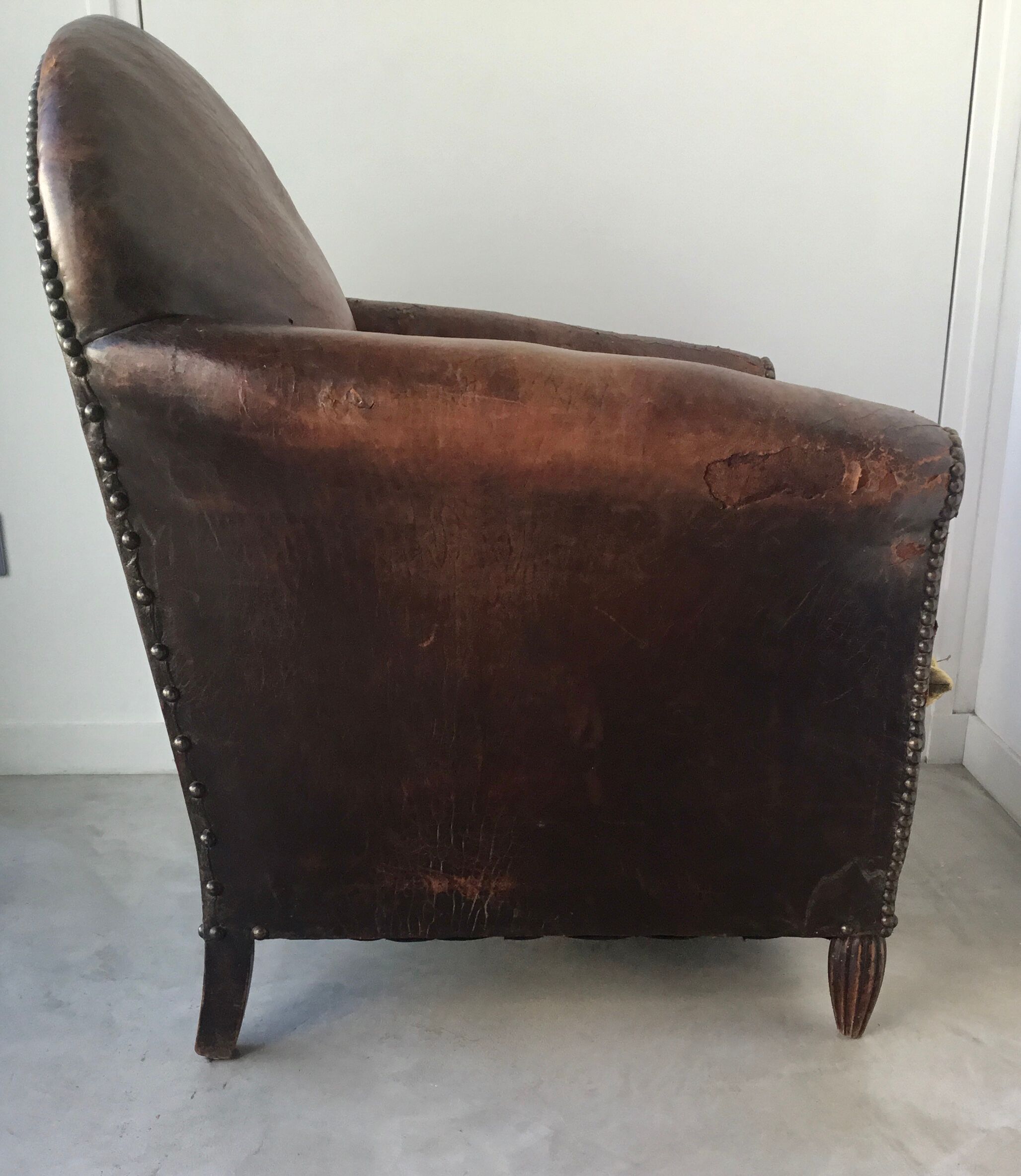 Club armchair in studded leather - early twentieth century