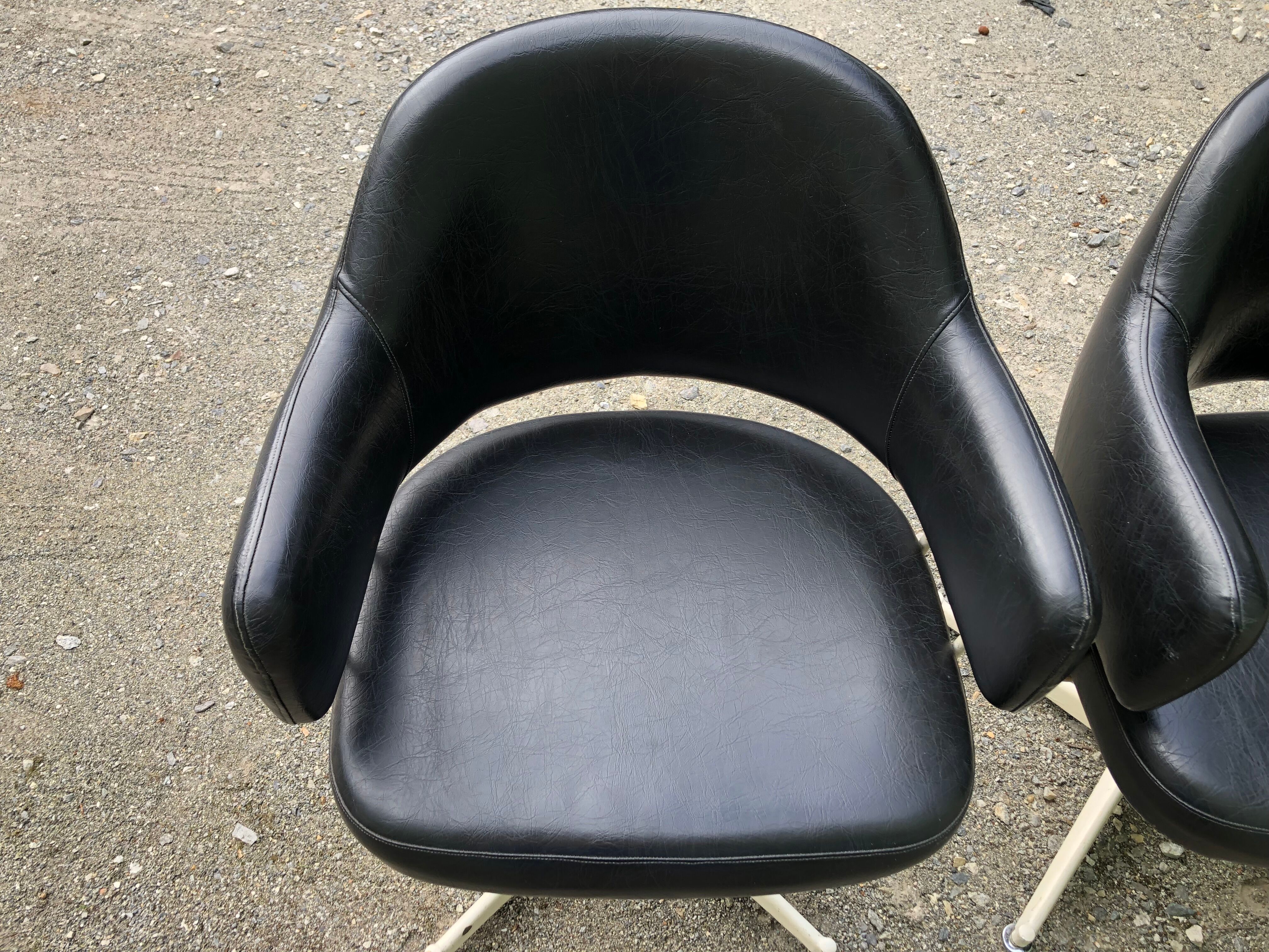Pair of vintage armchairs in black skai with metal legs.