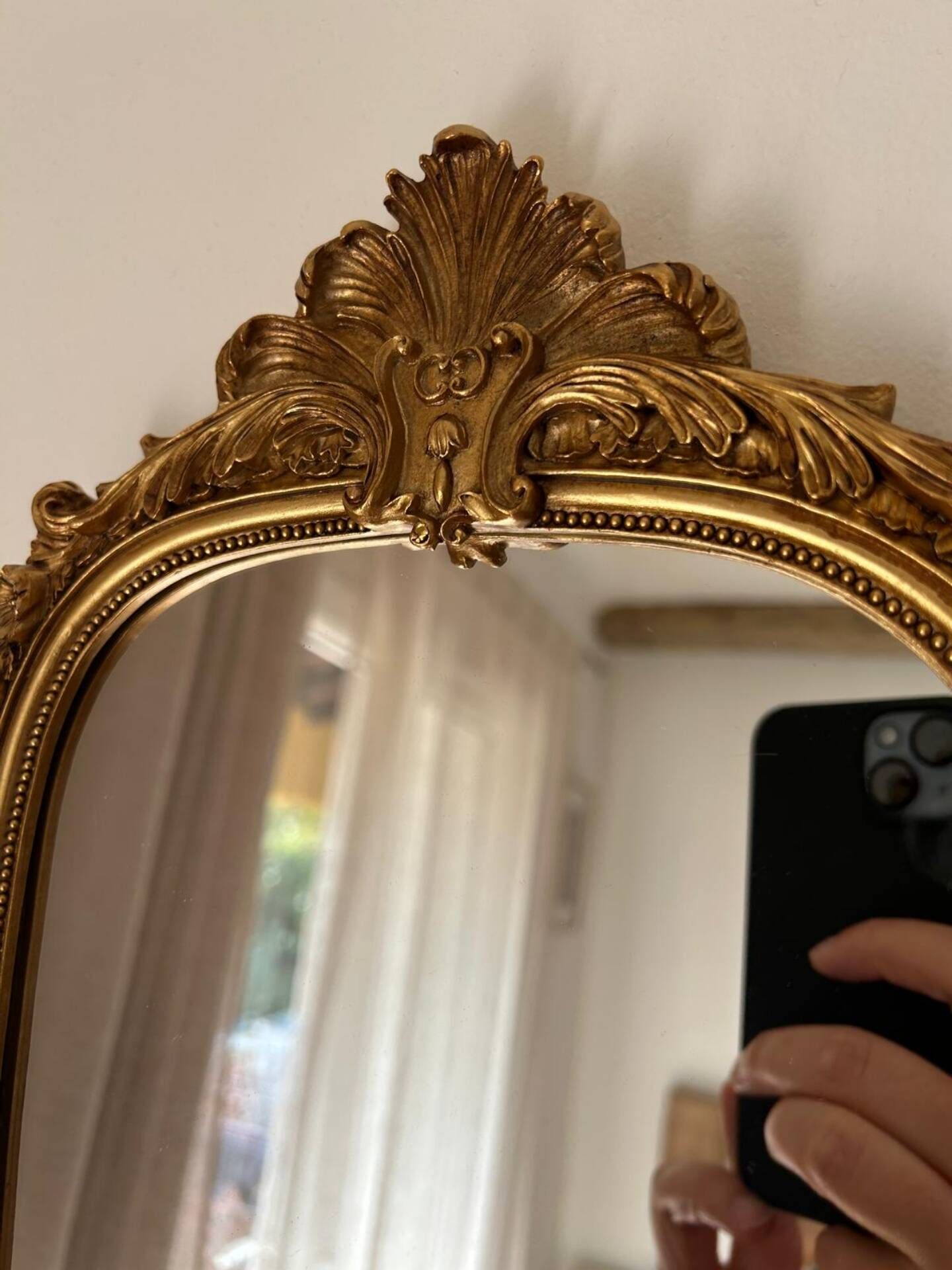 Miroir décoratif avec moulures et fronton.