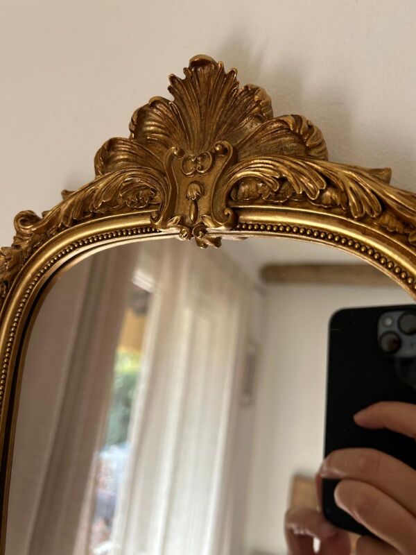 Miroir décoratif avec moulures et fronton.