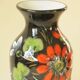 Vintage black ceramic vase with painted floral decoration – stylised colourful flowers.