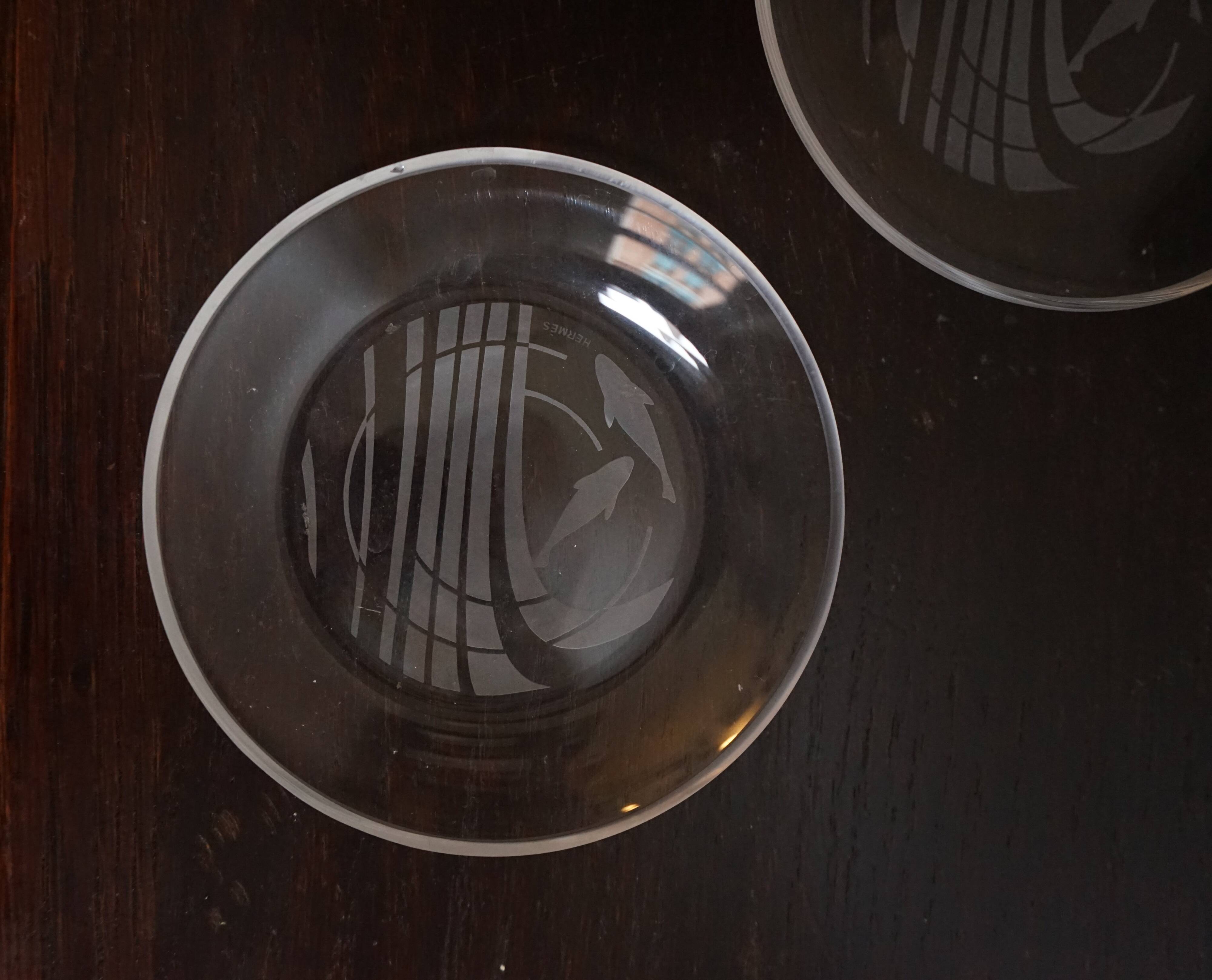 Hermès pair of glass plates with a dolphin pattern.