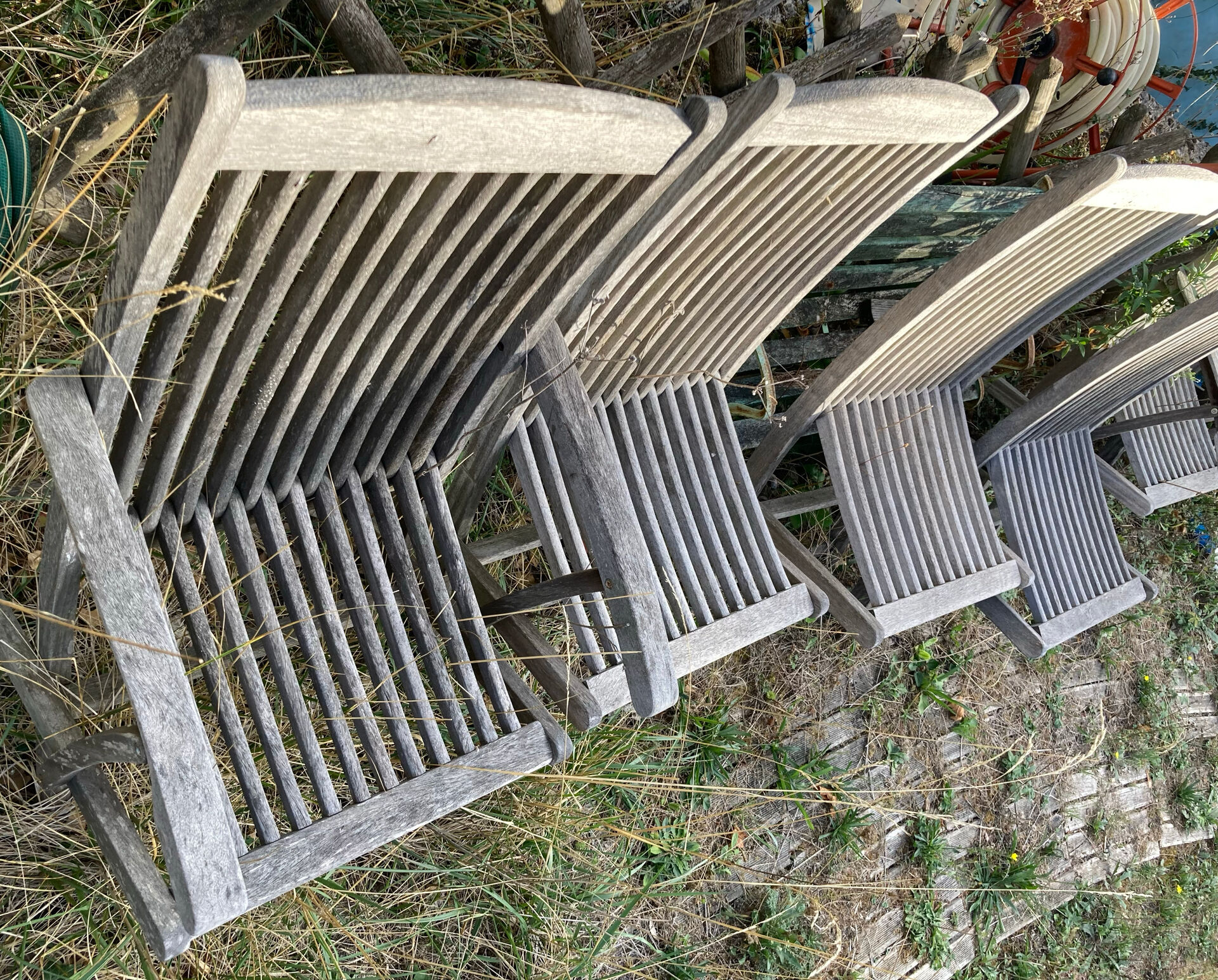 Folding garden chairs and armchairs in River Han dowelled teak.