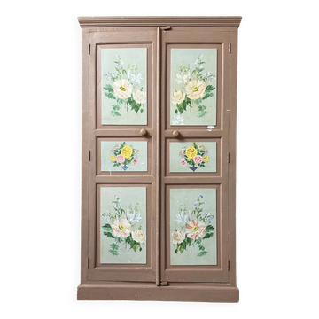 Large antique wardrobe painted with floral decoration.
