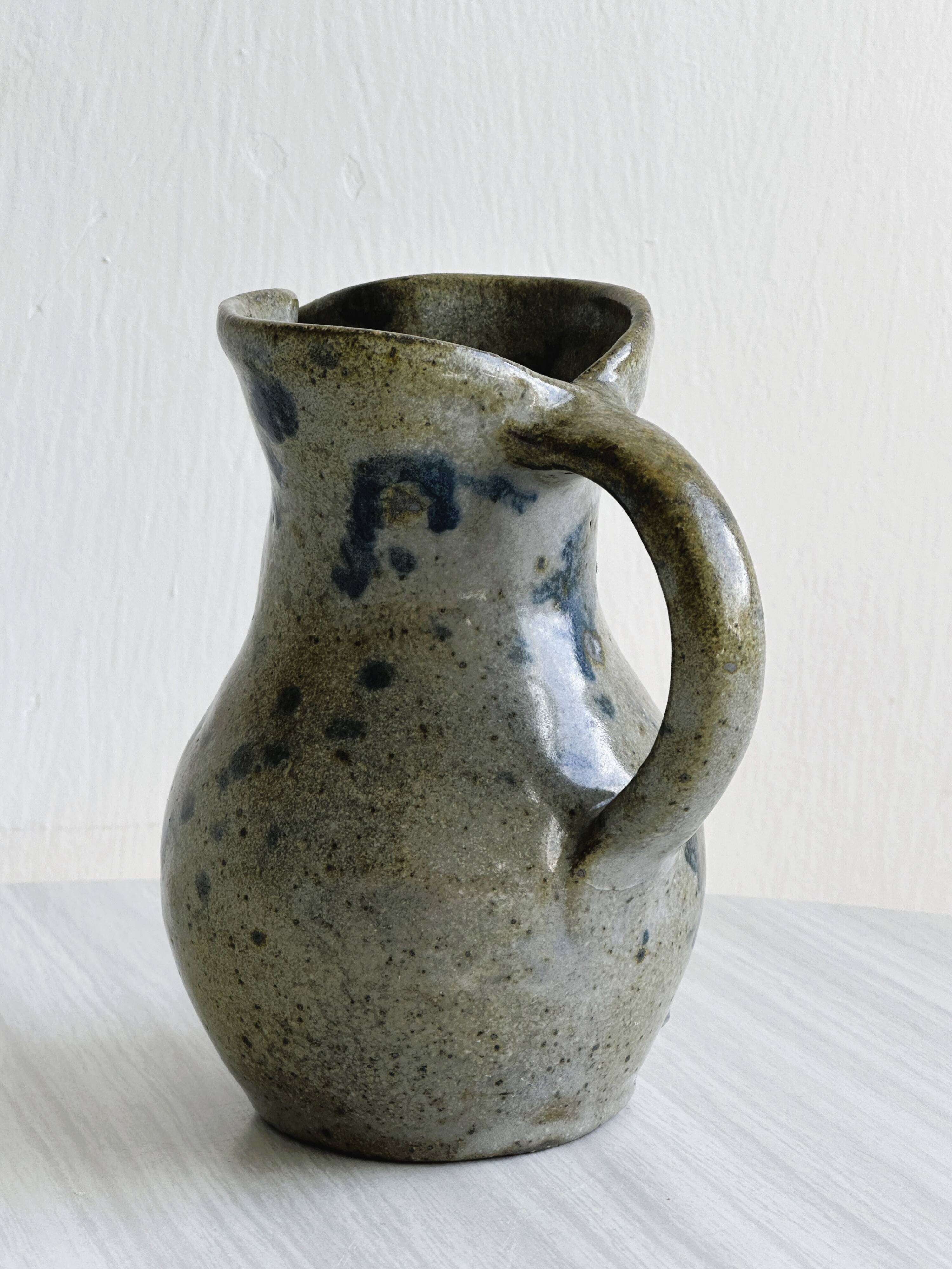 Small handcrafted ceramic pitcher with spotted enamel