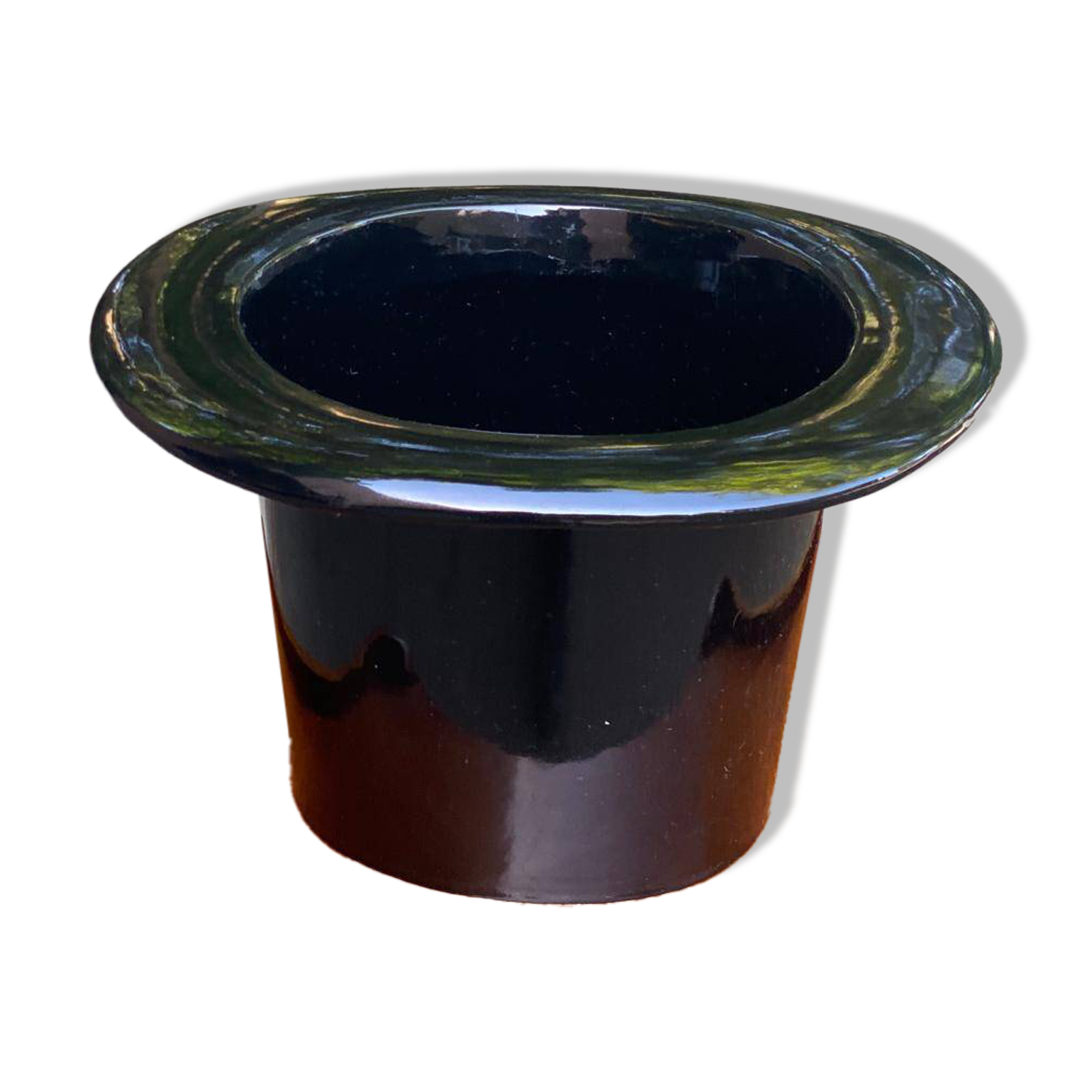 A black top hat-shaped vale turned upside down from the 1960s.