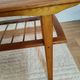 Scandinavian coffee table in teak with a lower shelf and brass bars.