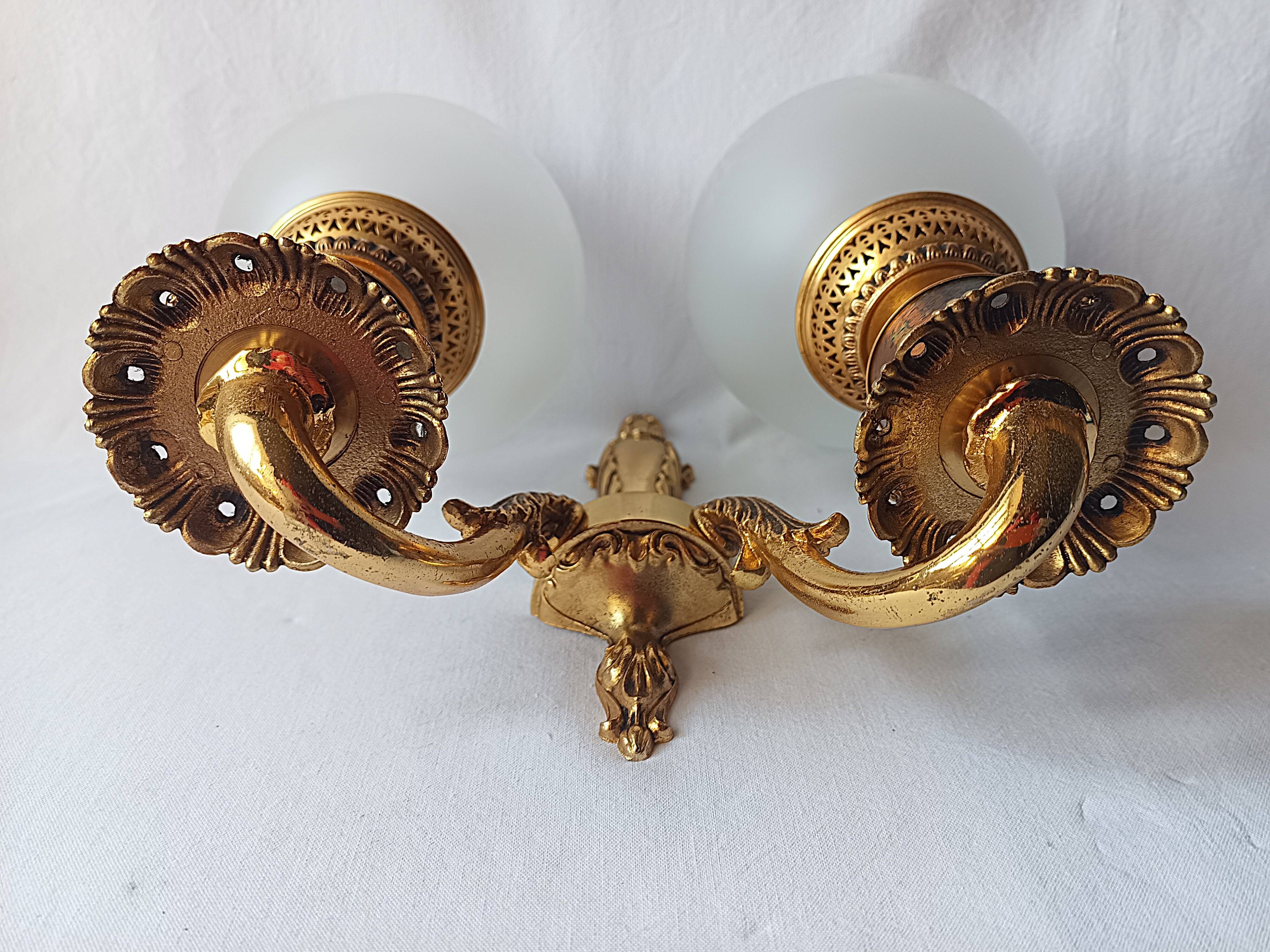 Wall lamp in gilded bronze with a lion's head and engraved globe.