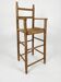 Old wooden high chair for children with a straw seat.