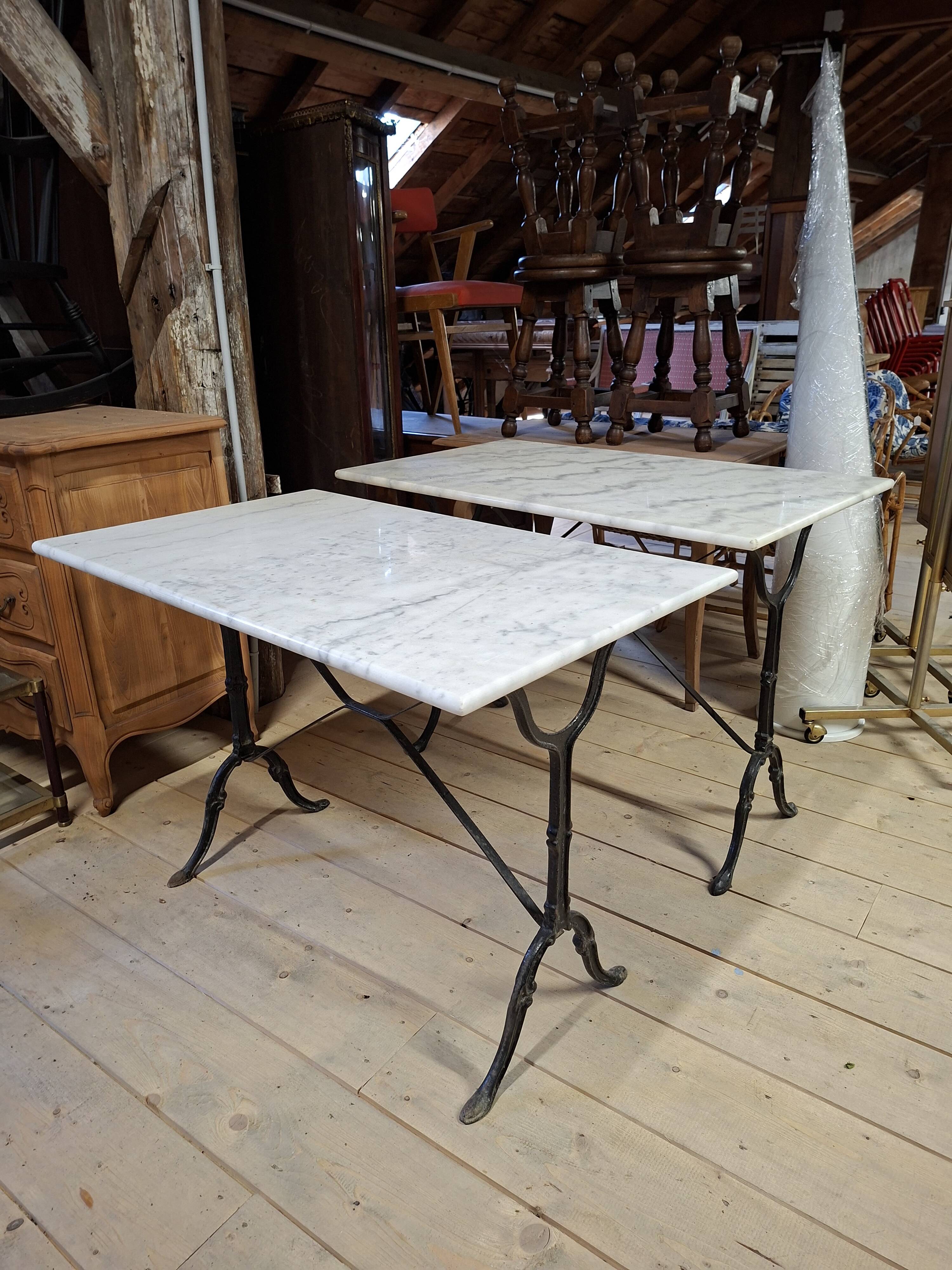 Pair of bistro tables in marble and cast iron.