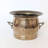Vintage round cache-pot in hammered brass with decorative handles and patina.