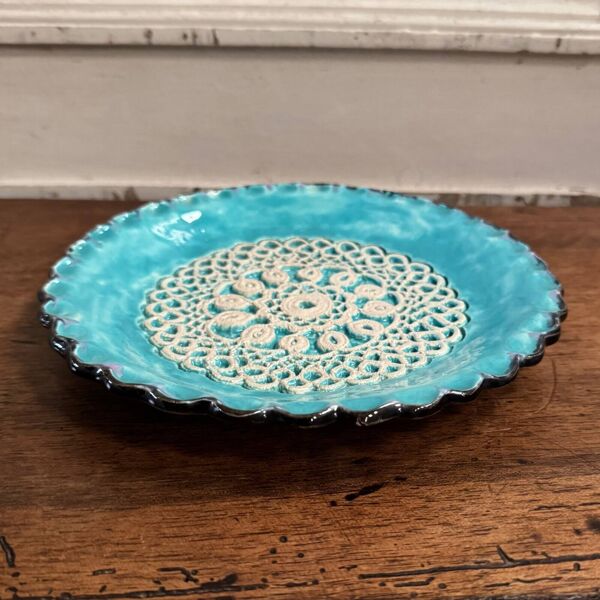 Assiette en émail fond bleu XXe ornementée d'une dentelle