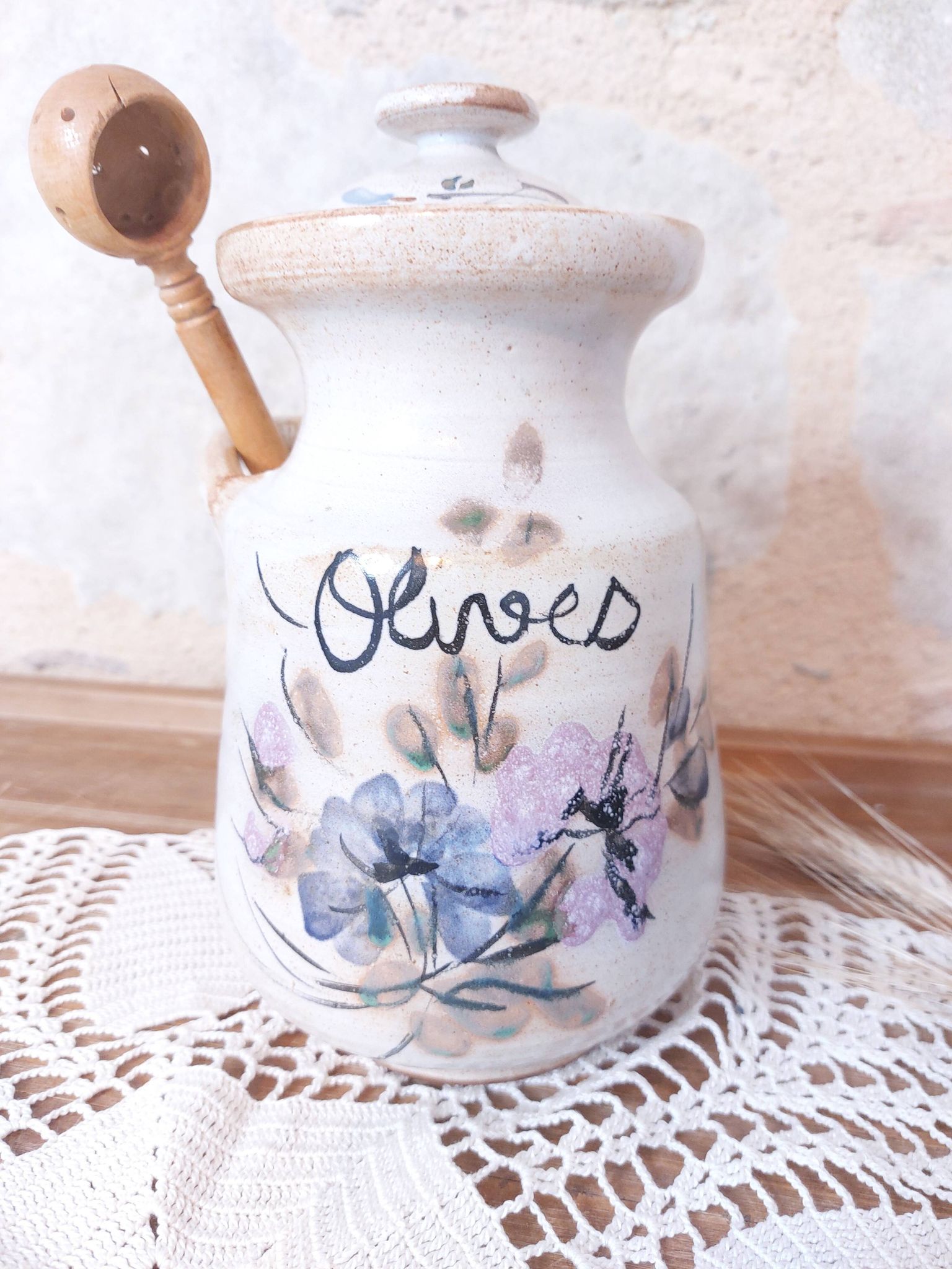 Old large vintage stoneware olive pot with its wooden spoon