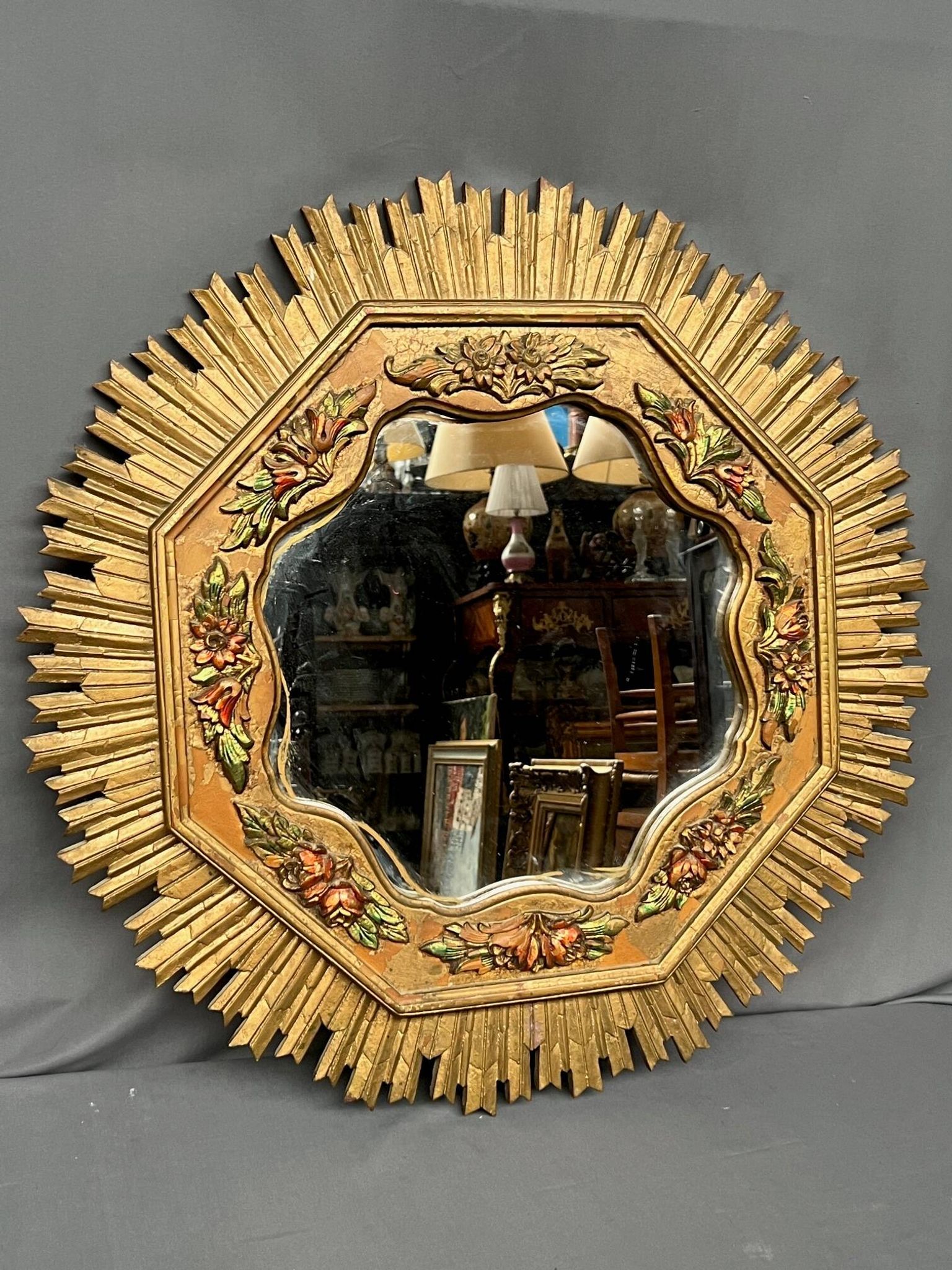 Large wooden mirror with golden sun rays, in Art Deco style.