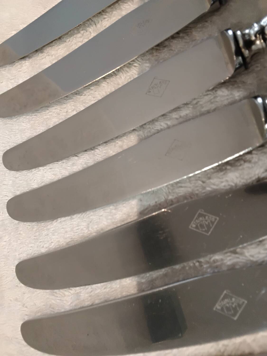 12 silver-plated metal dessert knives with rocaille ribbon decoration, 21.4 cm