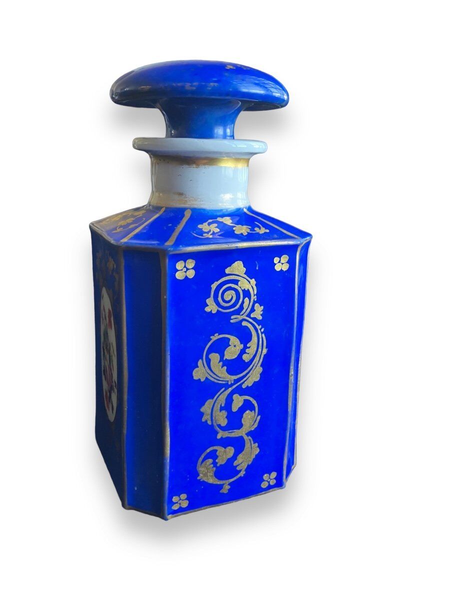 Perfume bottle in porcelain of old paris blue background