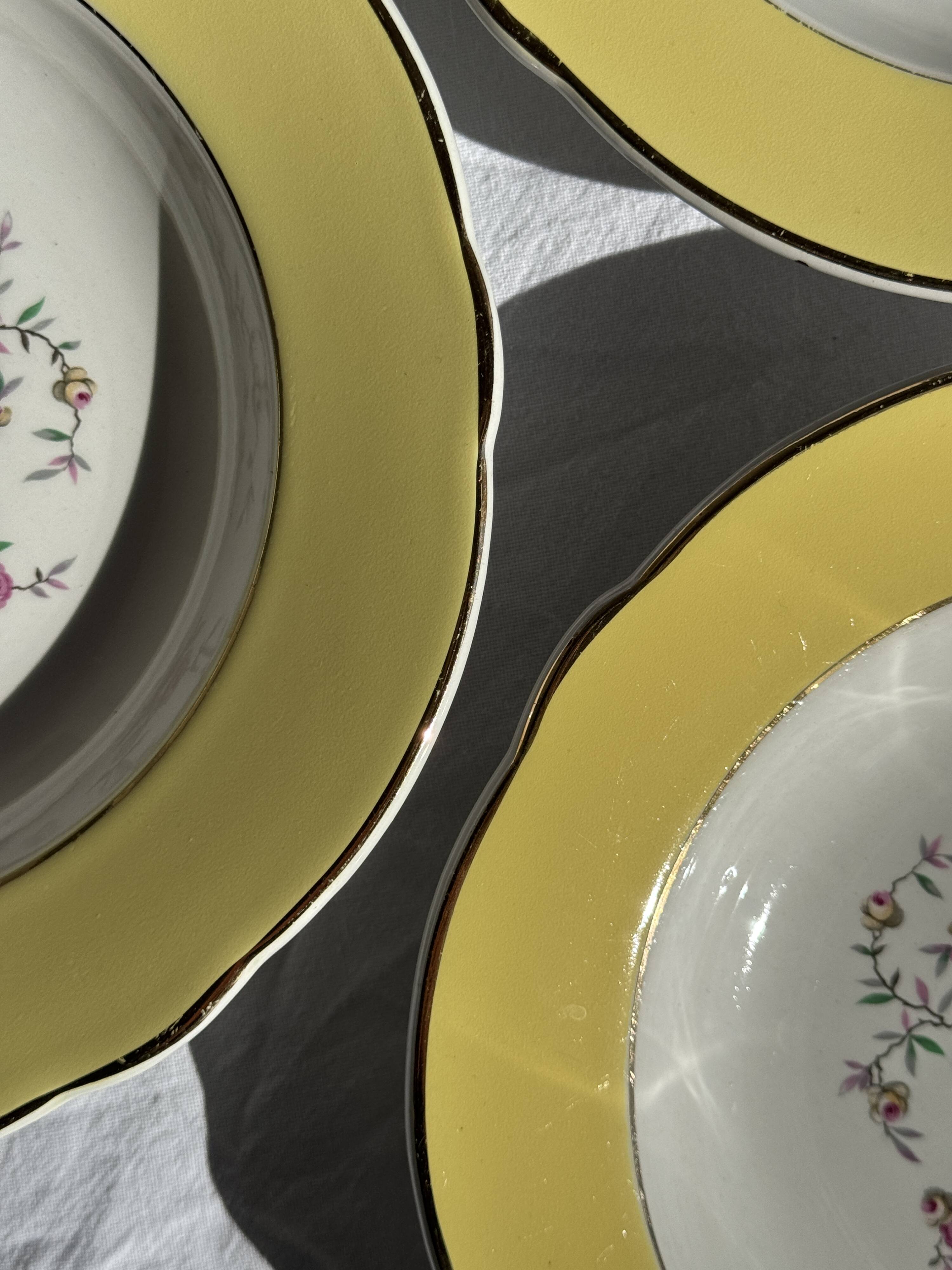 Set of 9 large vintage yellow deep plates with pink flowers and a gold rim.