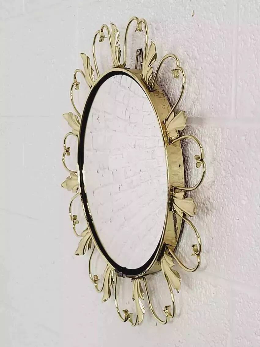 Round mirror on brass frame with scrolls