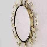 Round mirror on brass frame with scrolls