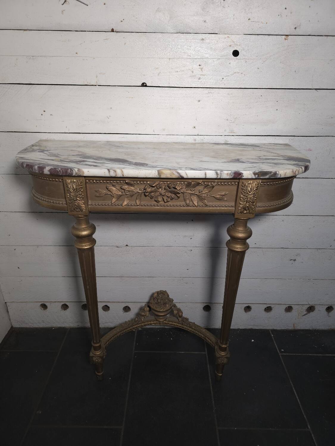 Louis XVI style console in gilded wood with a marble top.